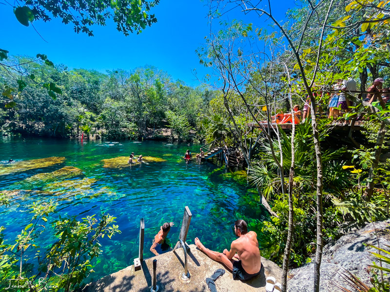 Eden cenote people sitting on a platform by the water